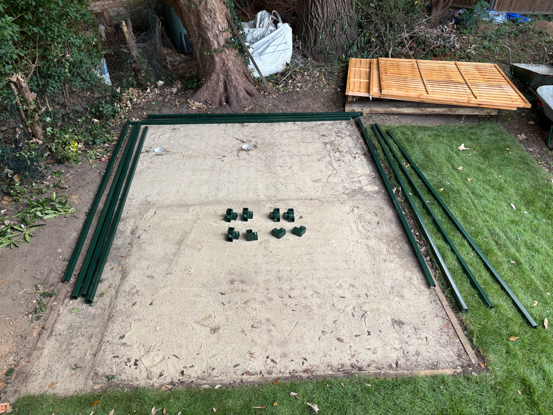 Golf cage base being levelled and prepared in a UK garden before frame assembly