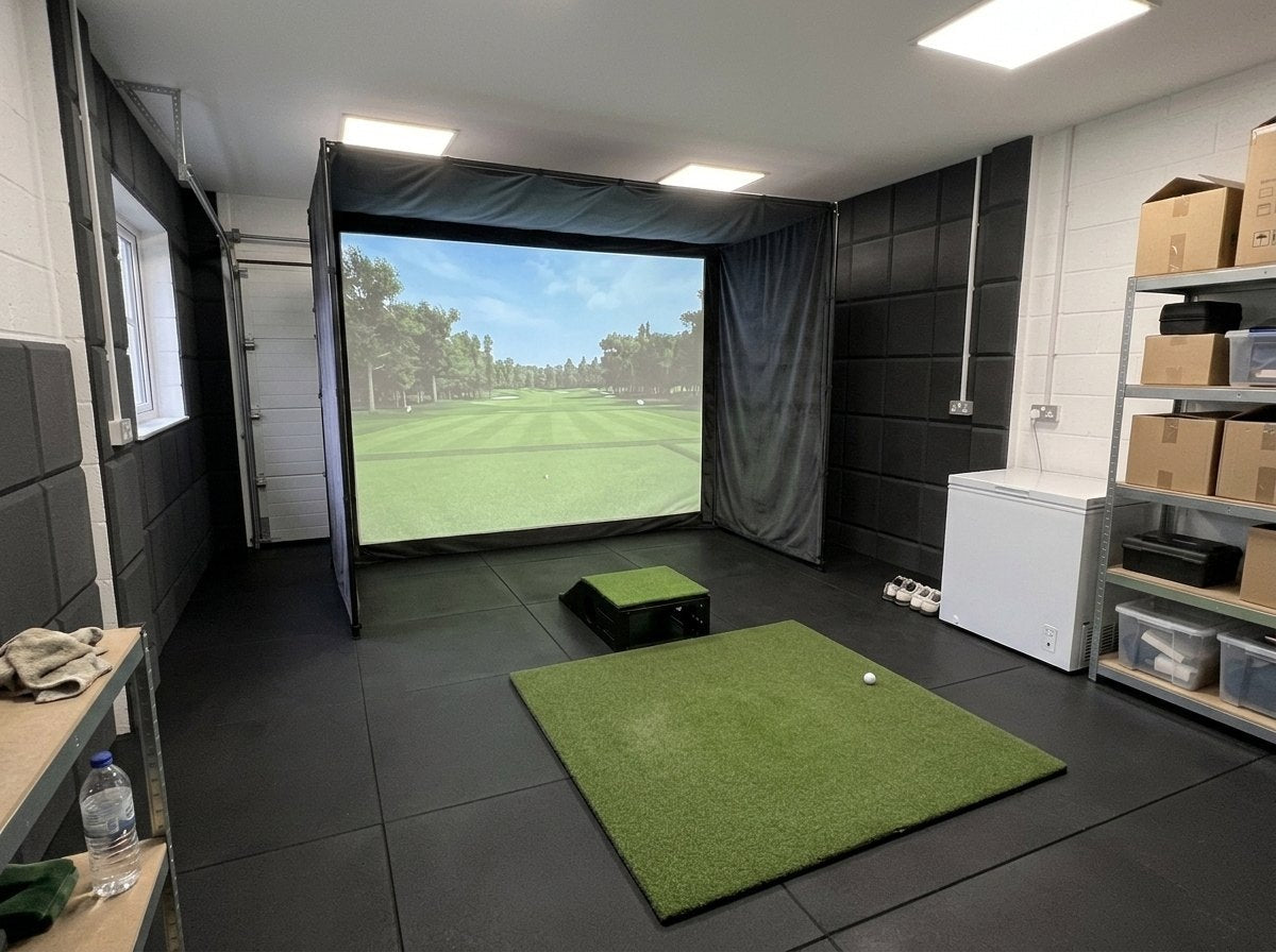 Illustration: golf simulator enclosure, hitting mat and a floor projector case in front of the mat in a UK double garage, using half the floor, daylight; black rubber flooring and black foam wall tiles