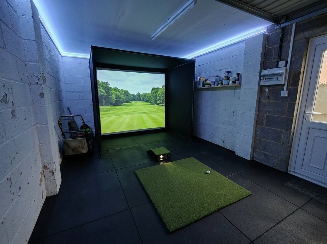 Illustration: golf simulator enclosure, hitting mat and a floor projector case in front of the mat in a UK single garage, LED strip lighting; black rubber flooring