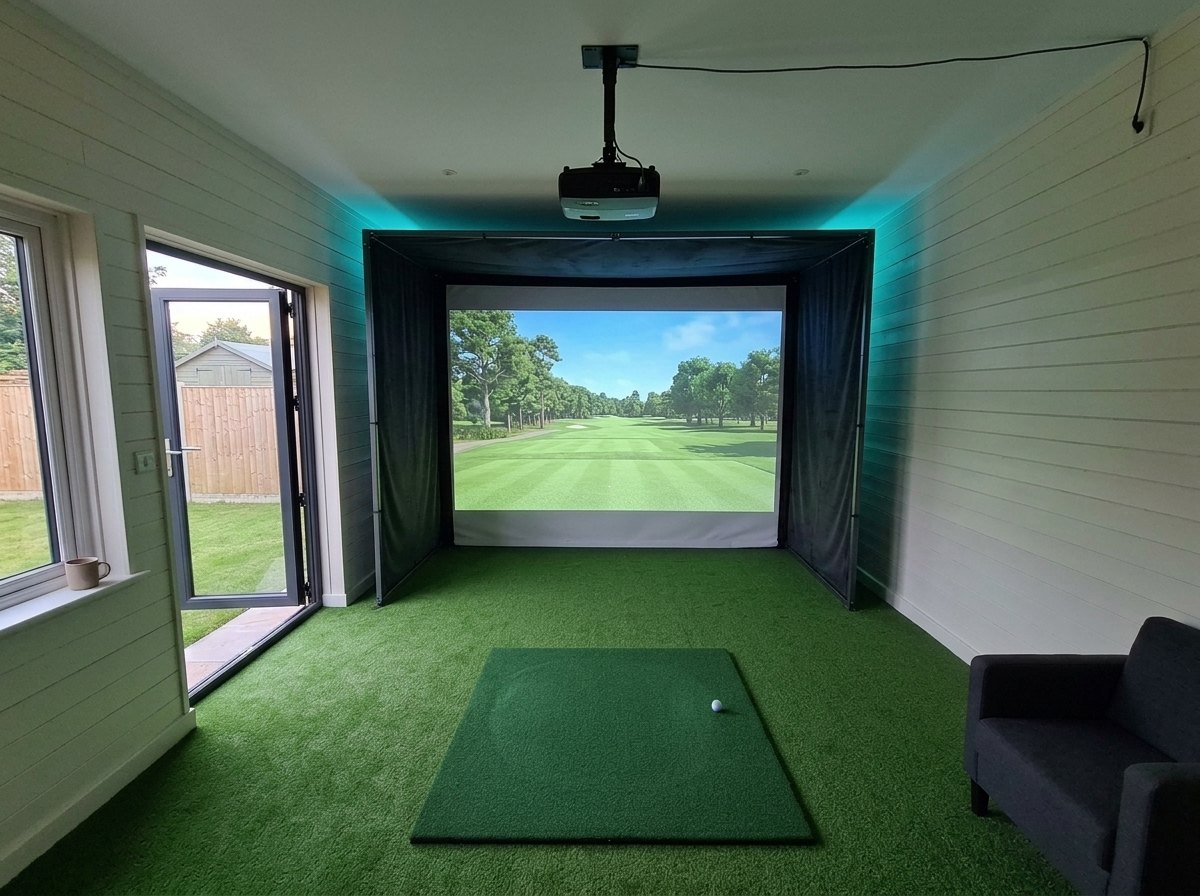Illustration: golf simulator enclosure, hitting mat and a ceiling-mounted projector in a UK garden room, LED strip lighting; artificial grass flooring