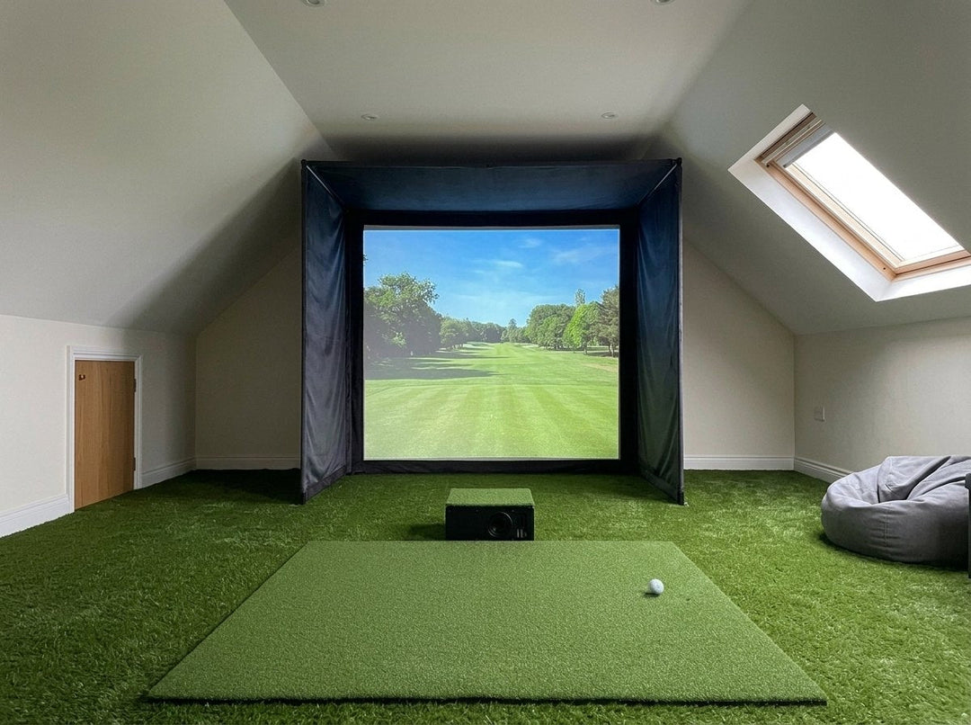 Illustration: golf simulator enclosure, hitting mat and a floor projector case in front of the mat in a UK loft conversion, daylight; artificial grass flooring