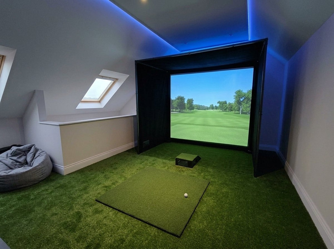 Illustration: golf simulator enclosure, hitting mat and a floor projector case in front of the mat in a UK loft conversion, LED strip lighting; artificial grass flooring