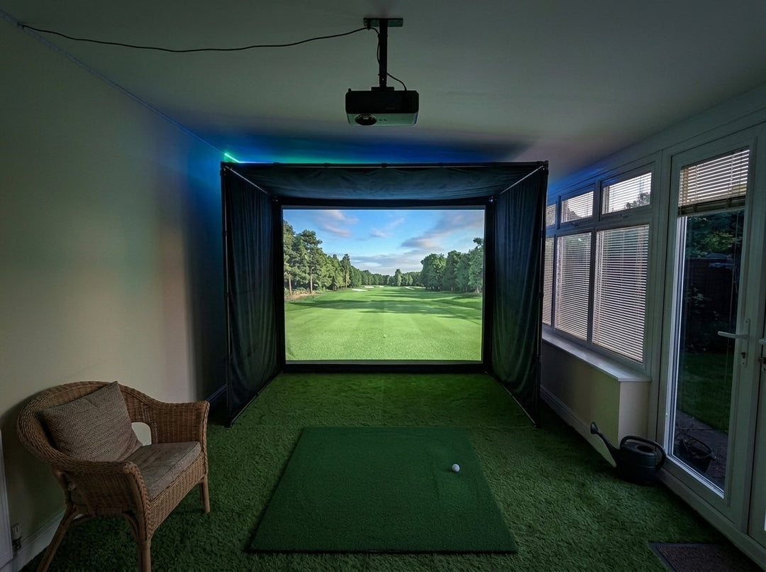 Illustration: golf simulator enclosure, hitting mat and a ceiling-mounted projector in a UK conservatory, LED strip lighting; artificial grass flooring