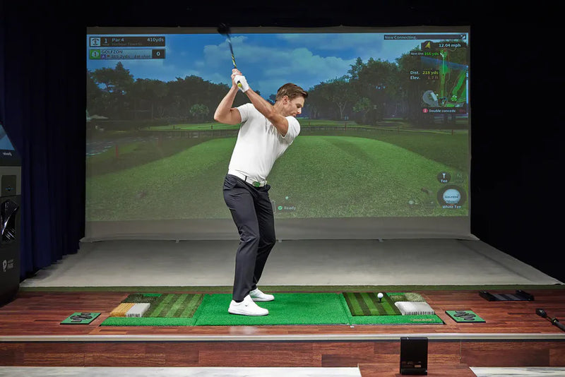 Golfzon WAVE indoor golf simulator enclosure setup showing projection and impact screen