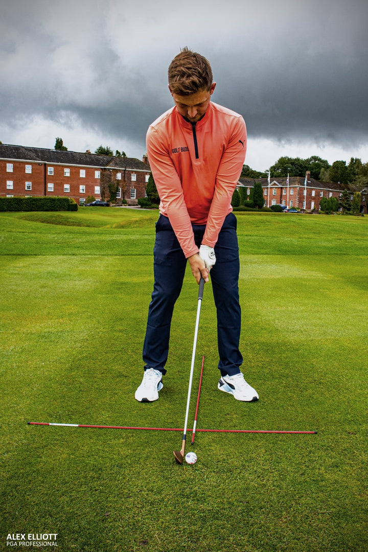 Alignment sticks used with golf net and mat for stance correction drills